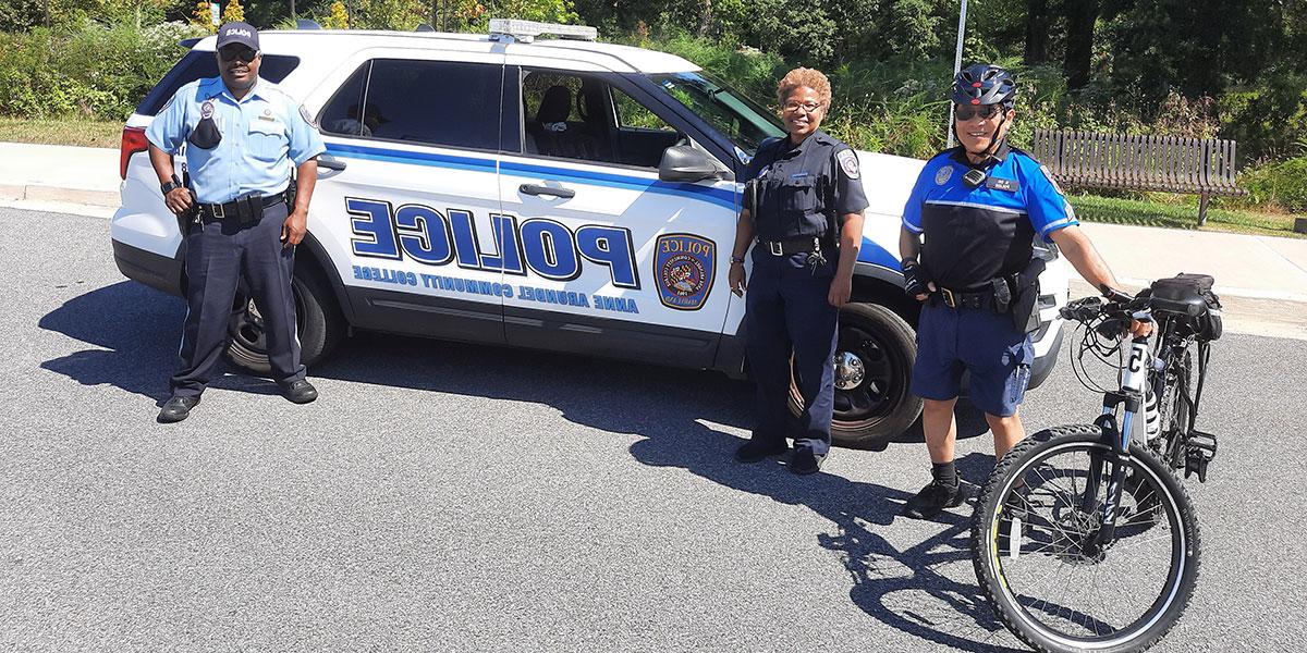 Various Public Safety officers standing in front of patrol car